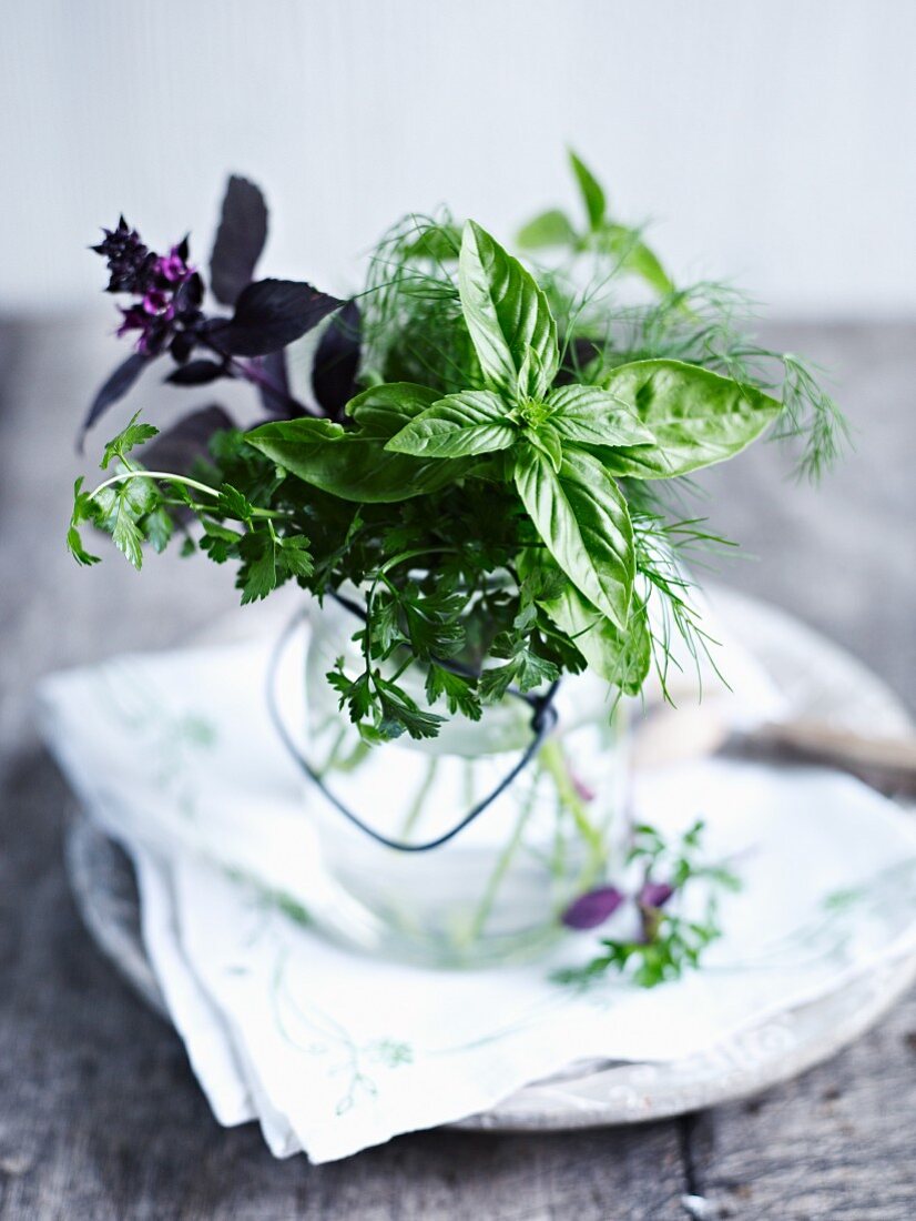 A bouquet of herbs in a glass of water