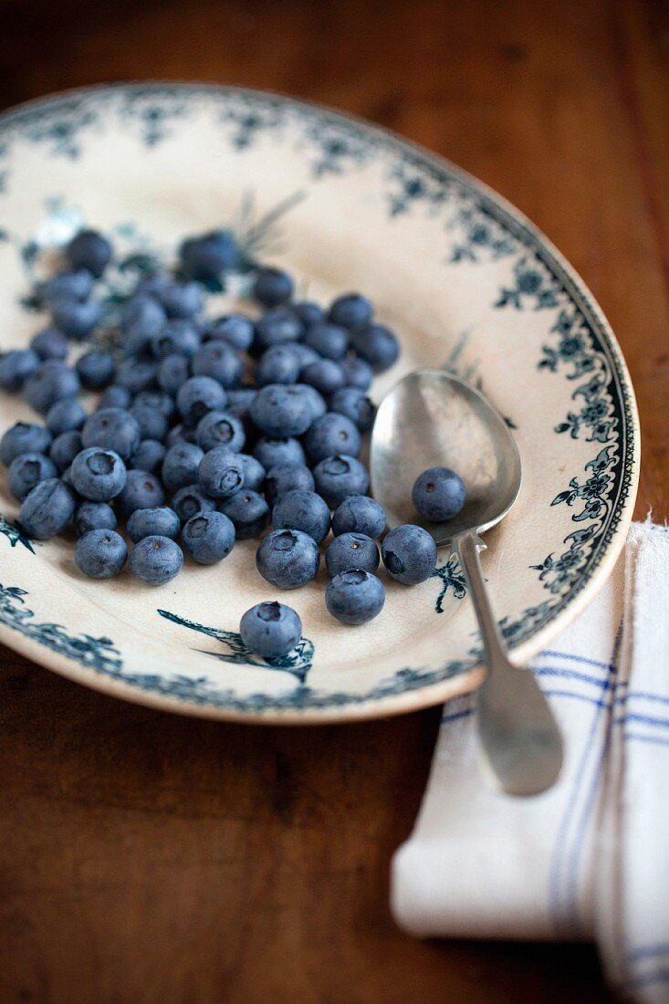 Blueberries with a spoon on a vintage plate