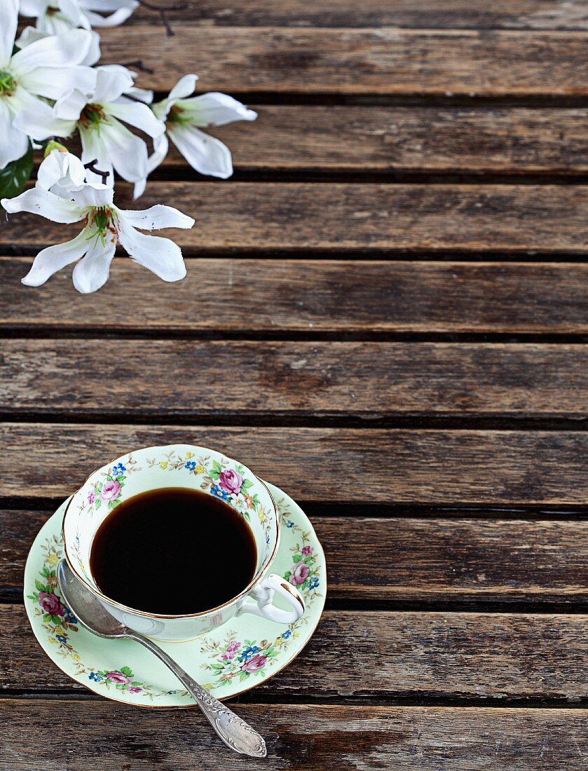 A cup of black coffee on an old wooden table