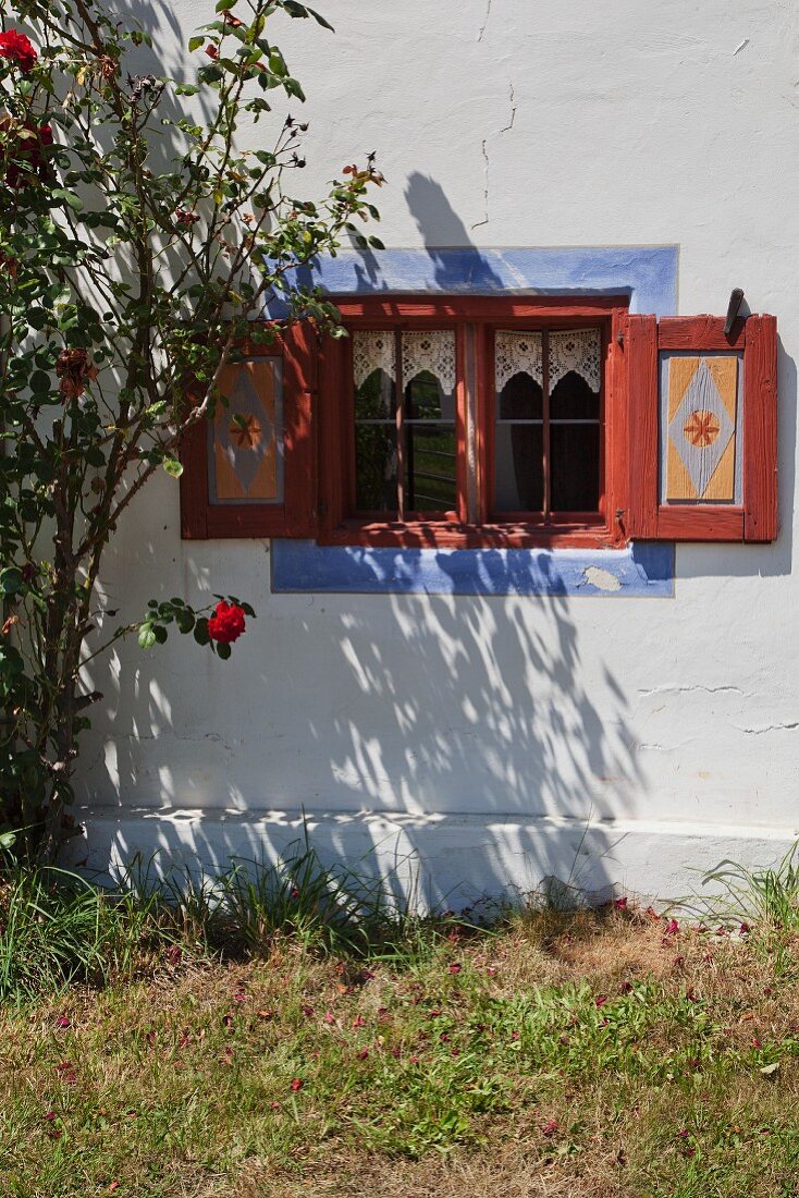 Fassadenausschnitt mit blauer Fasche um Fenster eines restaurierten Bauernhauses