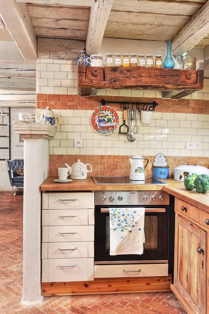 Rustic interior with white drawers in base units of open-plan kitchen