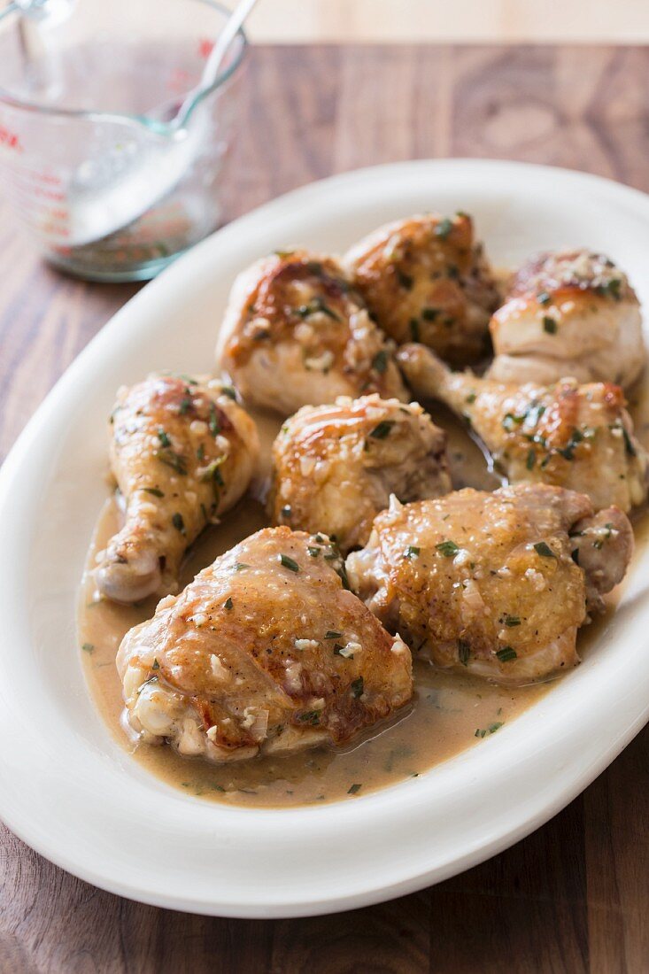 Braised chicken pieces with a vinegar sauce on an oval plate