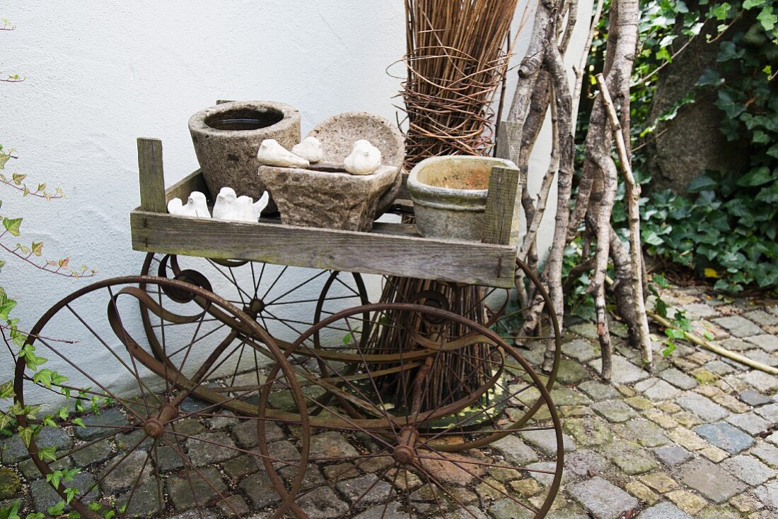 Various planters in wooden crate on antique pram frame