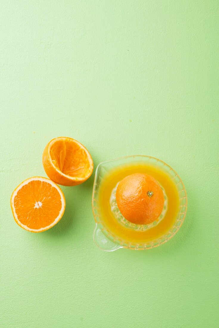 Orangenstilleben mit Orangenpresse und frisch gepresstem Saft