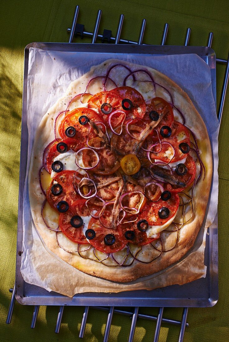 Pizza mit Tomaten, Oliven und roten Zwiebeln