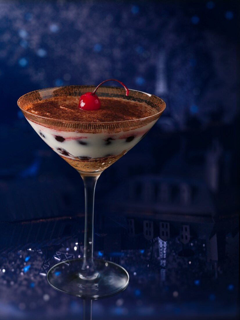 Tiramisu with a cocktail cherry in a stemmed glass