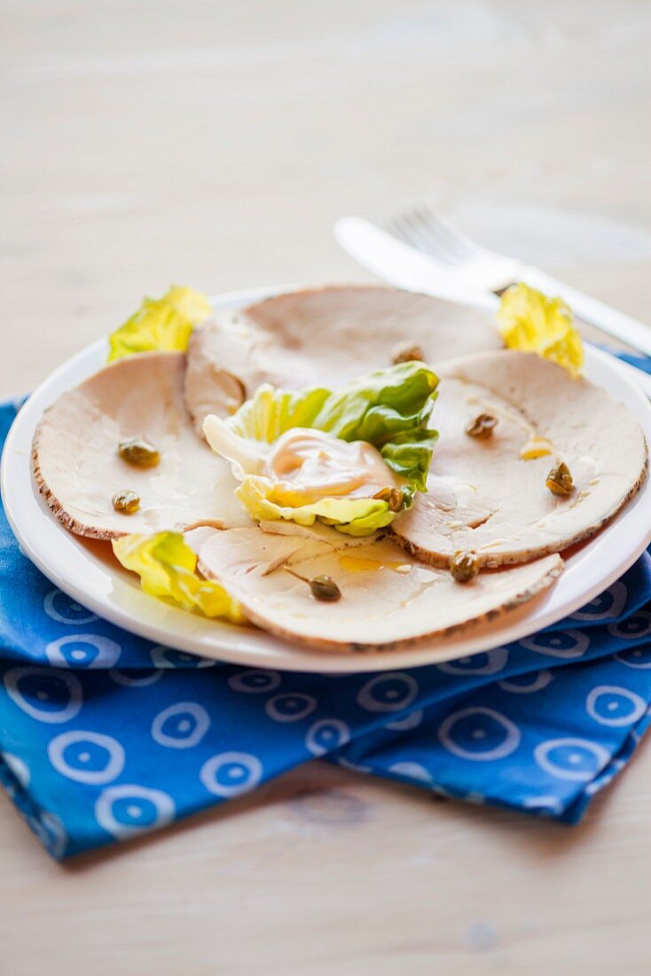 Putenbraten mit Mayonaise im Salatblatt und Kapern