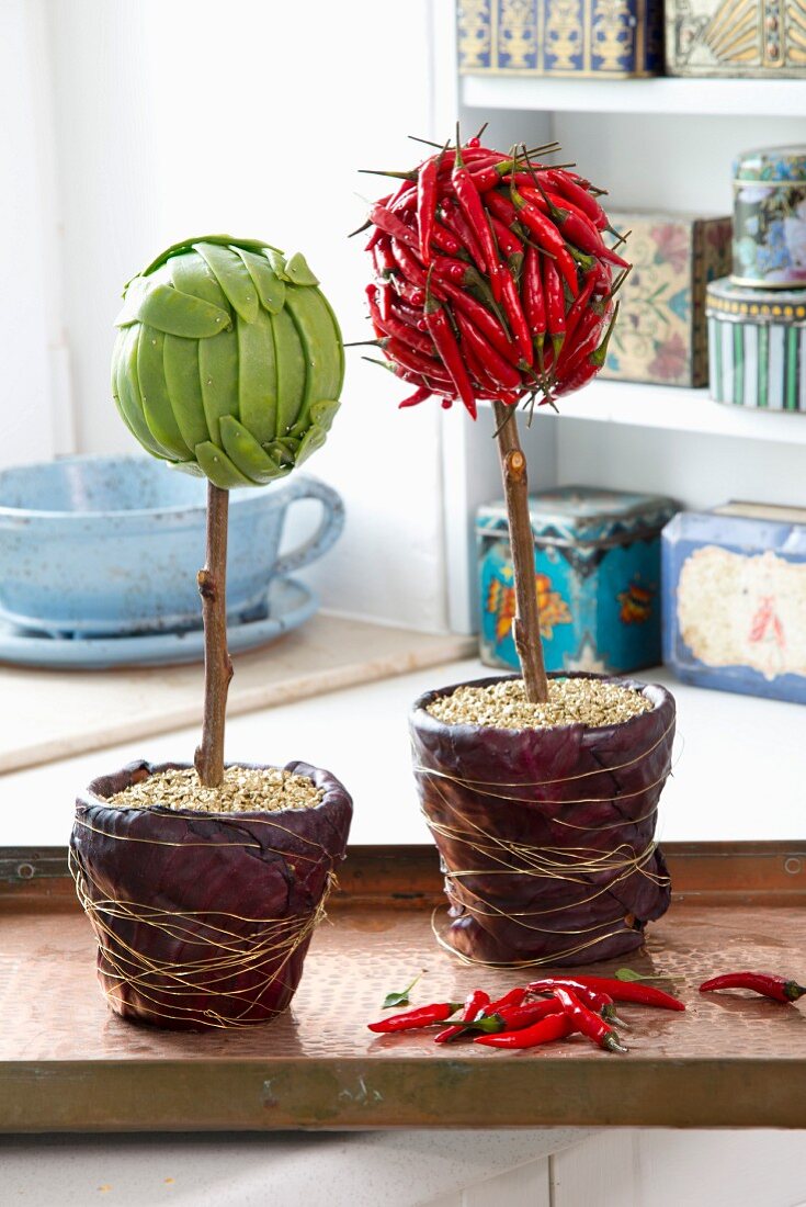 Aus Zuckerschoten und aus Chilischoten gebastelte Blumen, im Topf