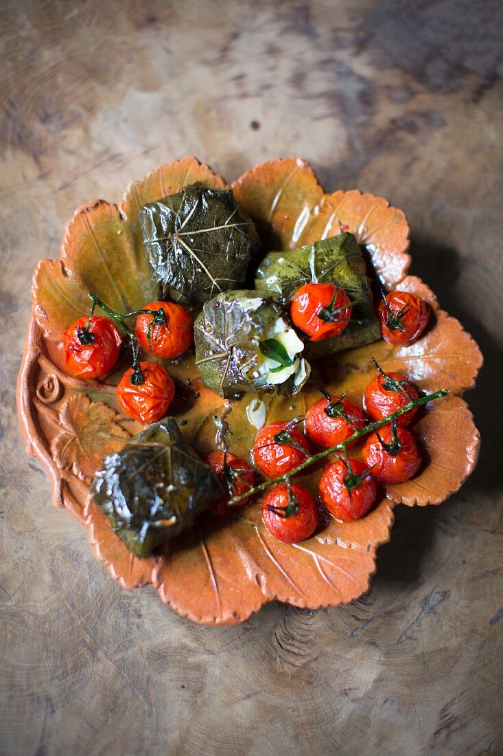 Stuffed, grilled vine leaves and cherry tomatoes