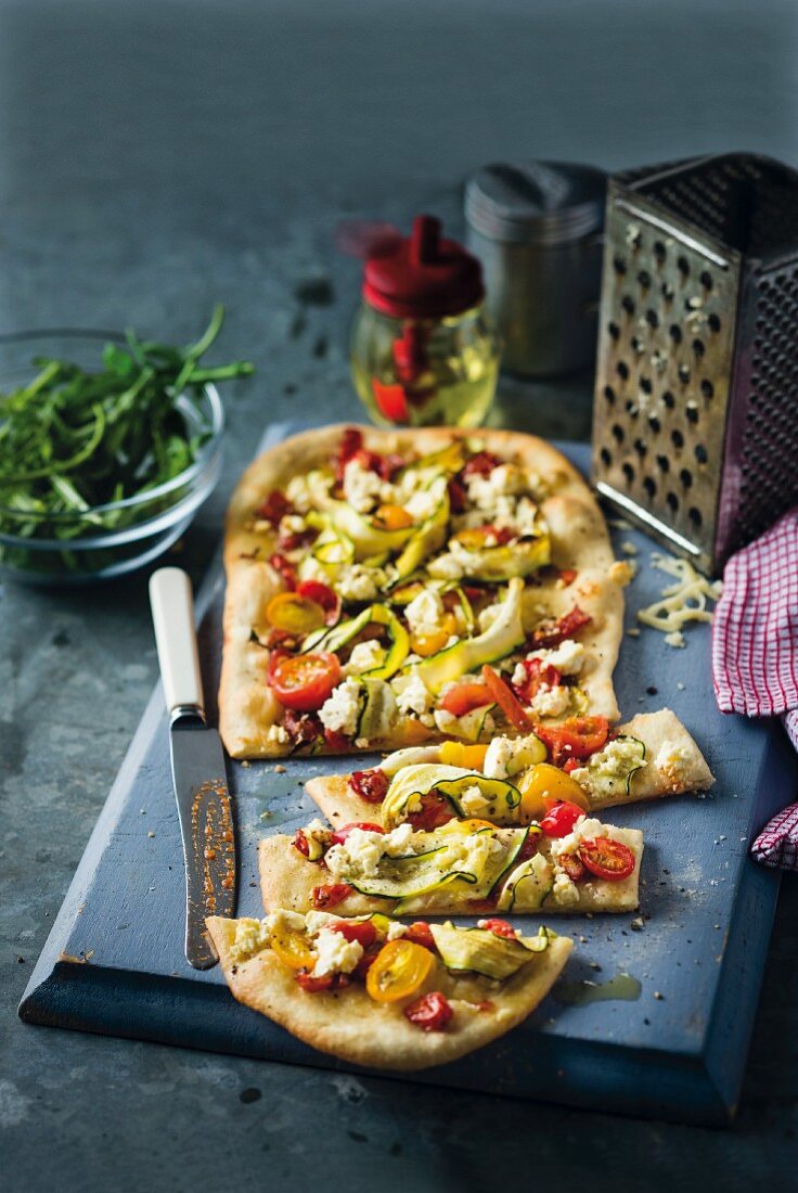 Pizza with tomatoes, courgette and sheep's cheese