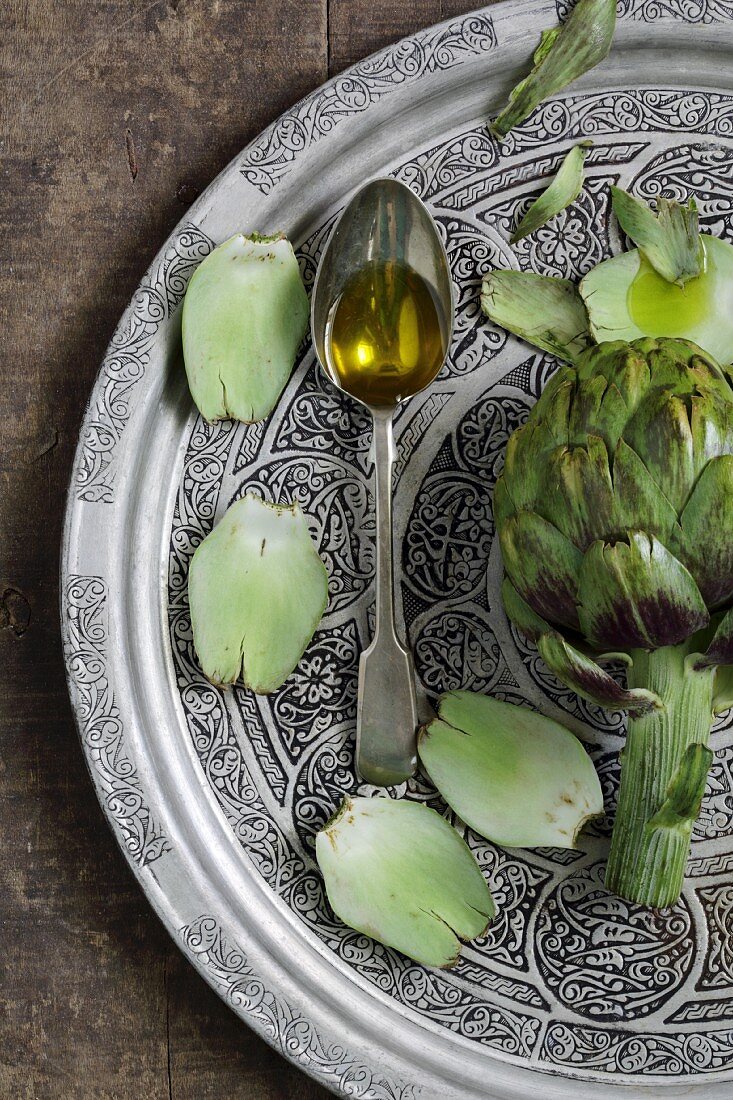 Olive oil on a spoon with artichokes