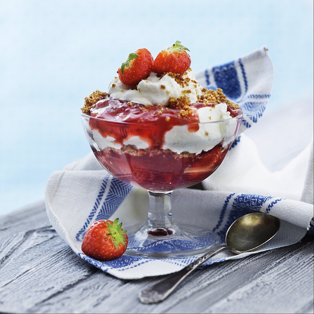 An ice cream sundae with strawberries and brittle