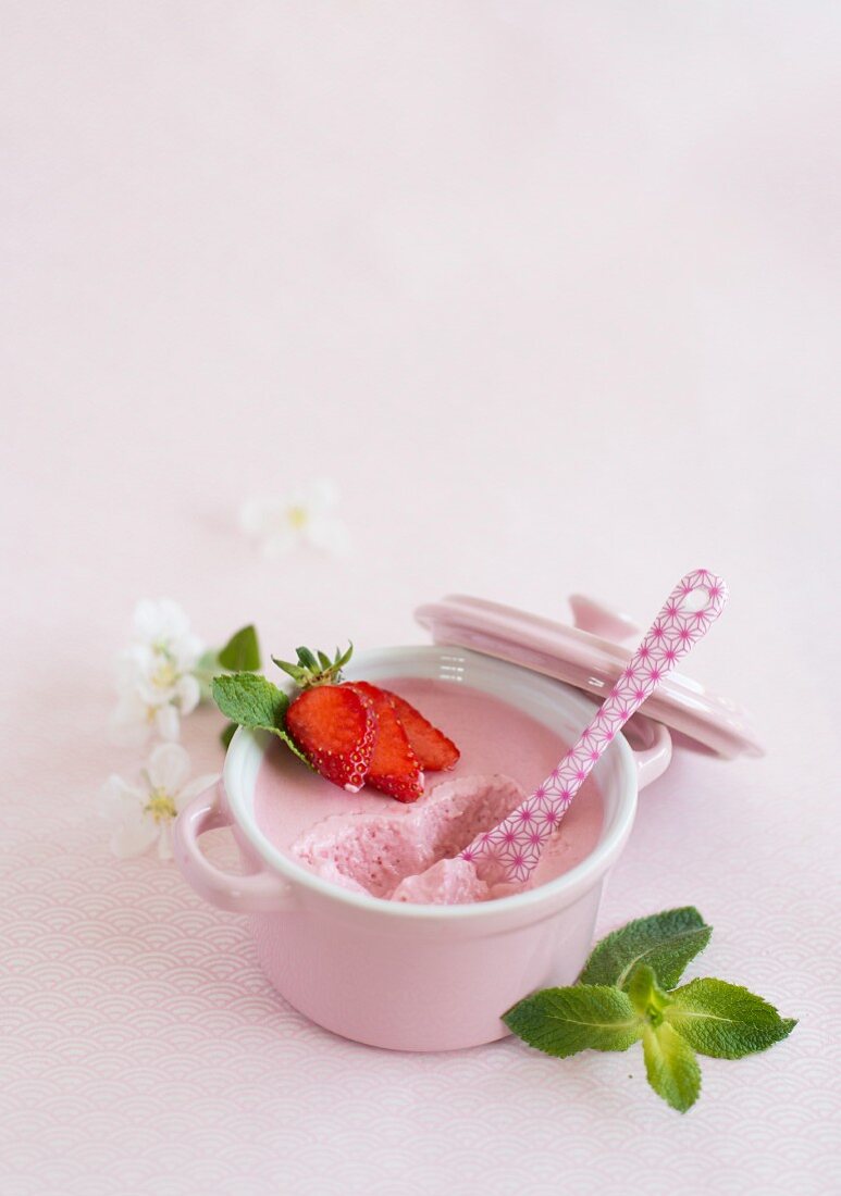 A bowl of strawberry mousse with a bite taken out