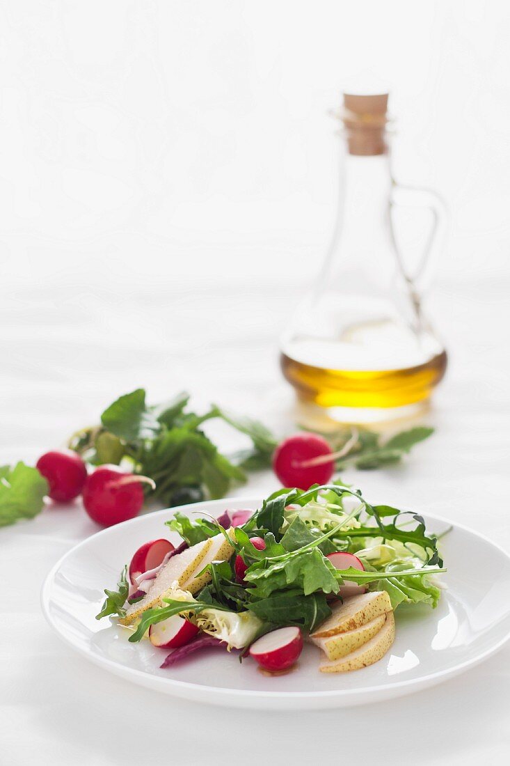 A healthy salad with radishs, pears and olive oil