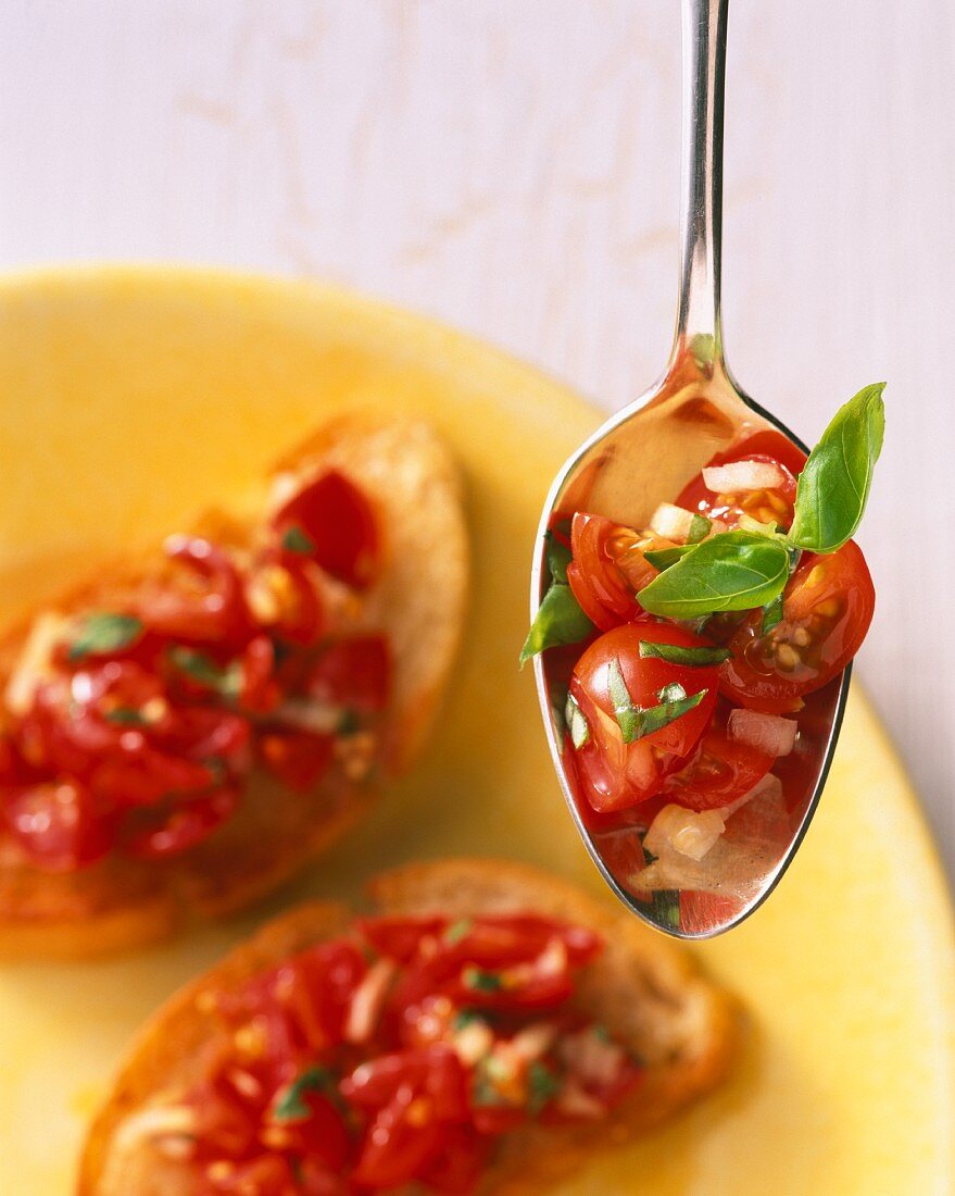Bruschetta and a spoonful of tomatoes, onions and basil
