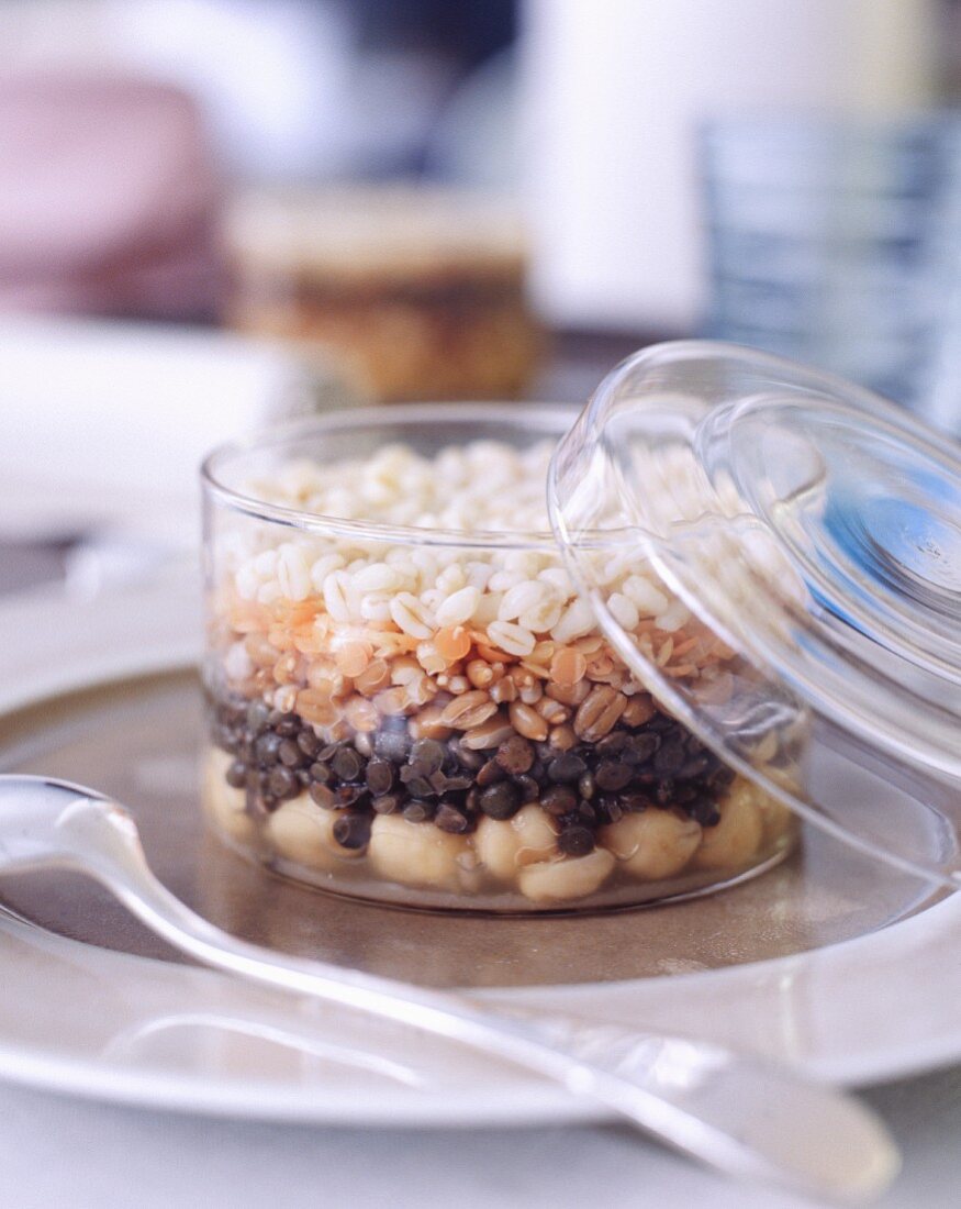 Layers of chickpeas, lentils and wheat in a glass container