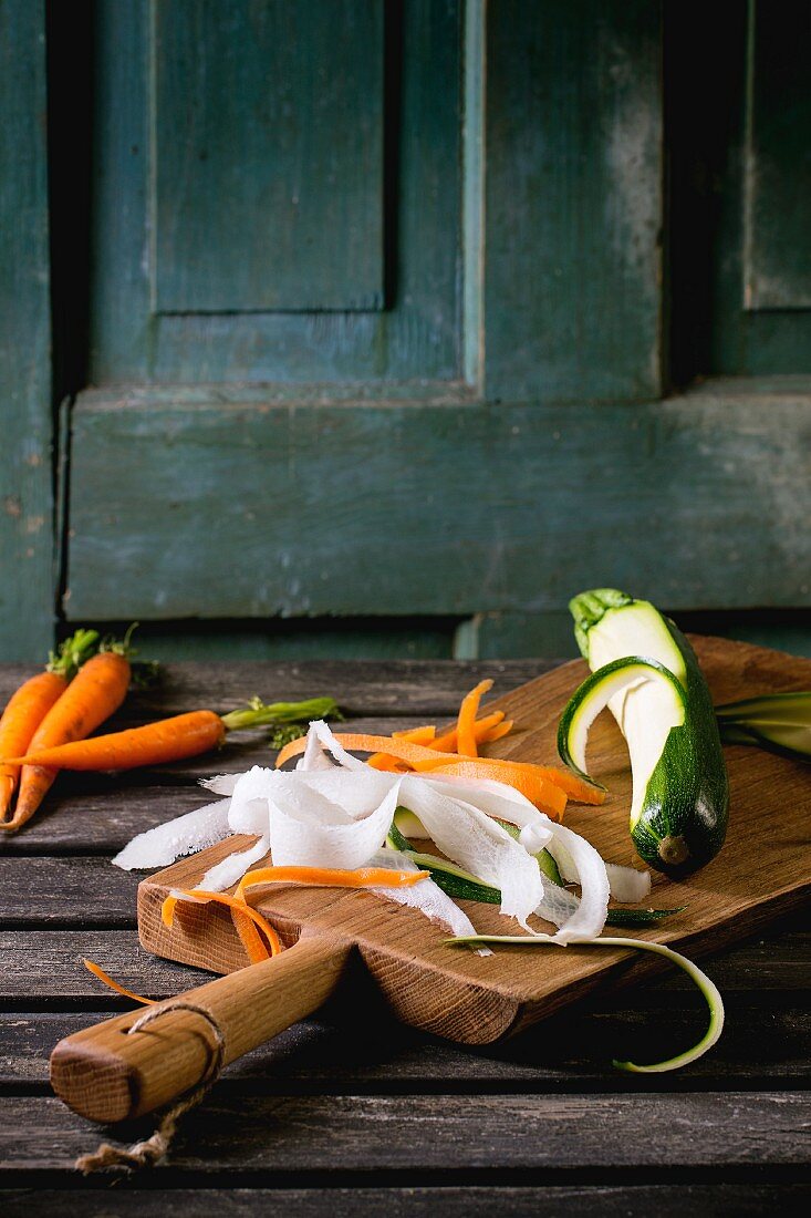 Grated vegetable noodles made from carrots, radishes and courgettes on a chopping board