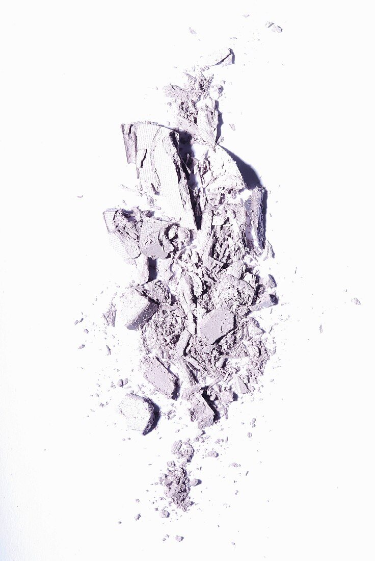 Purple eye shadow crumbled onto a white surface