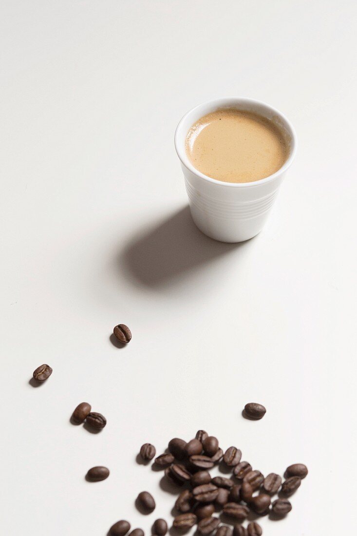 Espresso im Becher und Kaffeebohnen