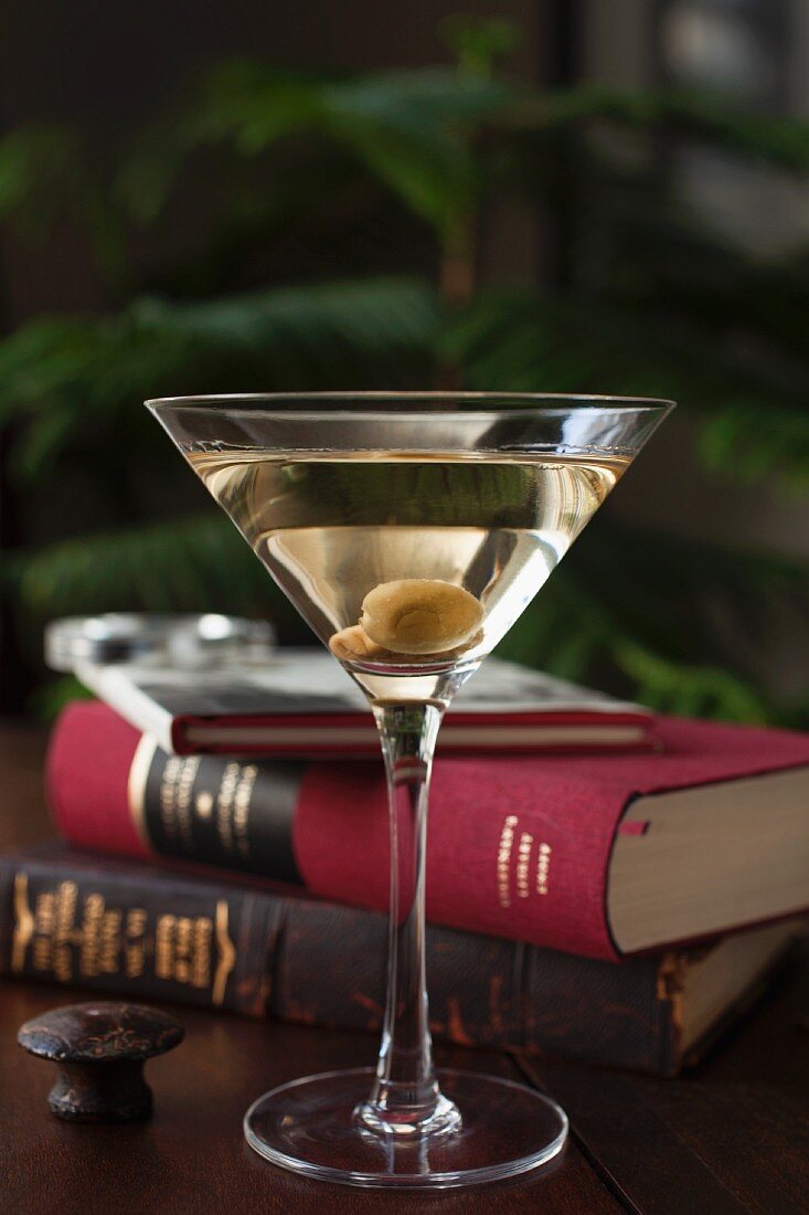 A dry Martini with olives and classic books in a den