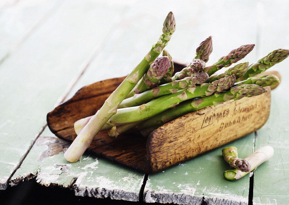 Green asparagus in wooden bowl
