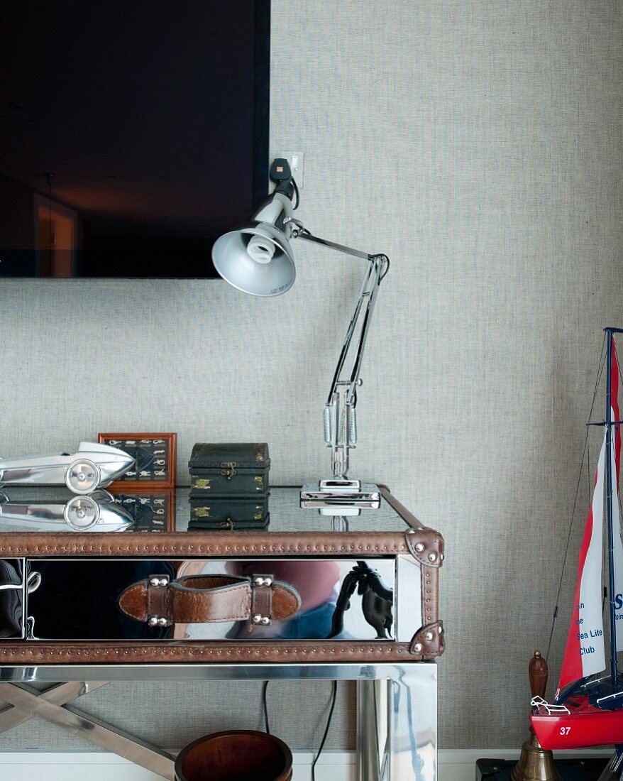 Desk lamp on table made from mirrored suitcase in bedroom