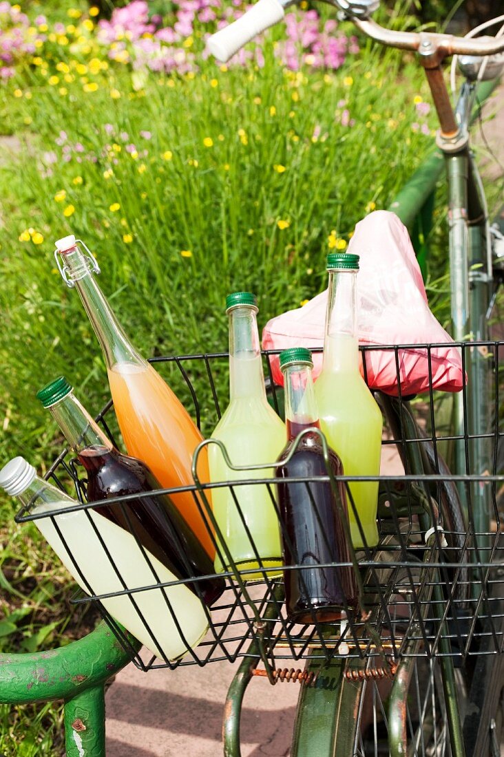 Bottles of various homemade lemonades in a bike basket