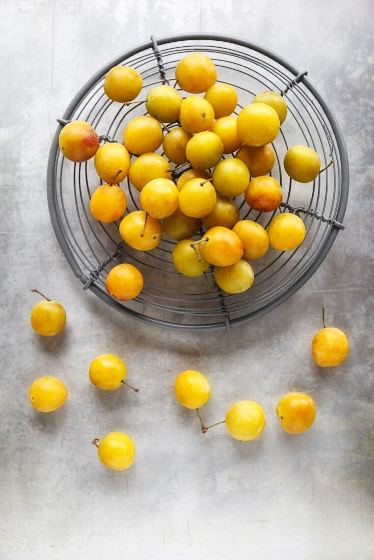 Yellow plums in a wire basket
