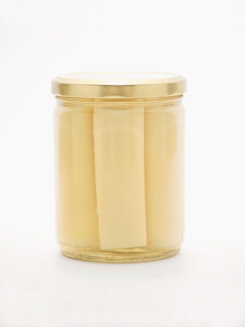 Hearts of palm in a jar on a white surface