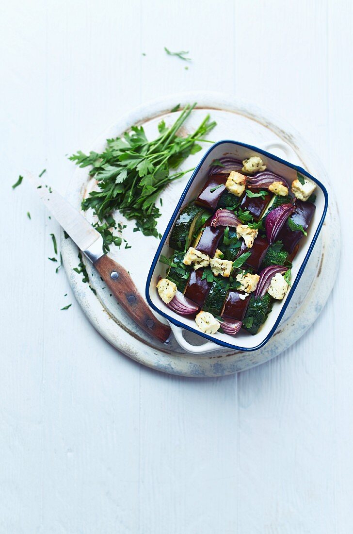Oven-baked aubergines and courgettes with goat's cheese and red onions