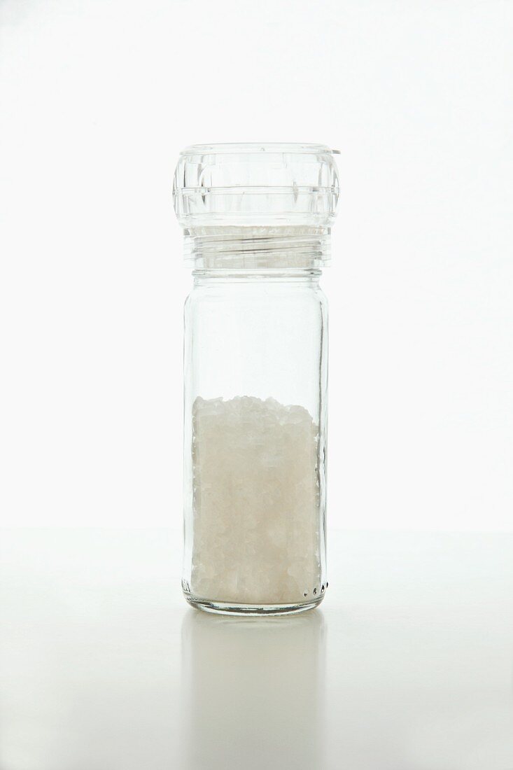Eine Salzmühle aus Plexiglas vor weißem Hintergrund