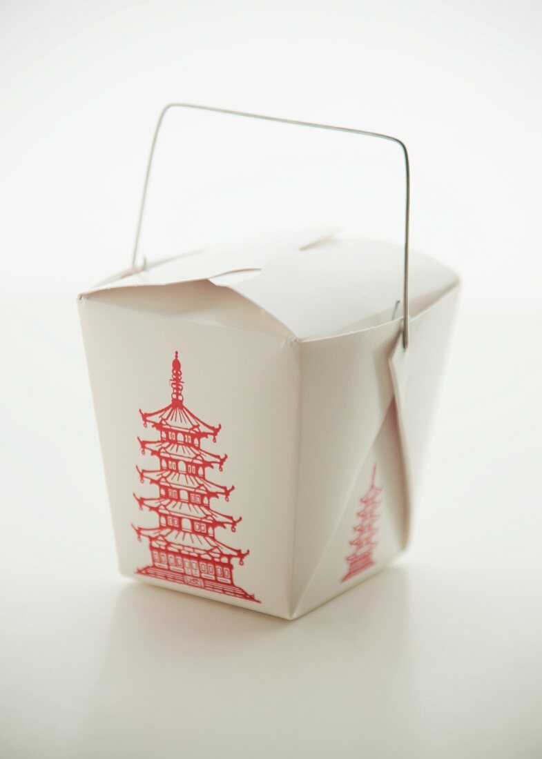 A takeaway box of oriental food on a white surface