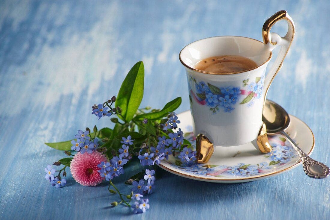 Kaffeetasse und Sträusschen aus Vergissmeinnicht und Bellis