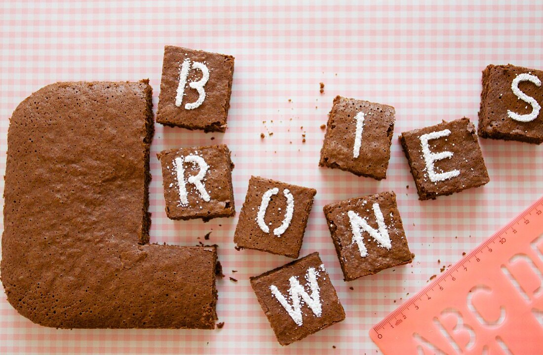 Kardamom-Brownies in Stücke geschnitten und verziert mit Buchstaben
