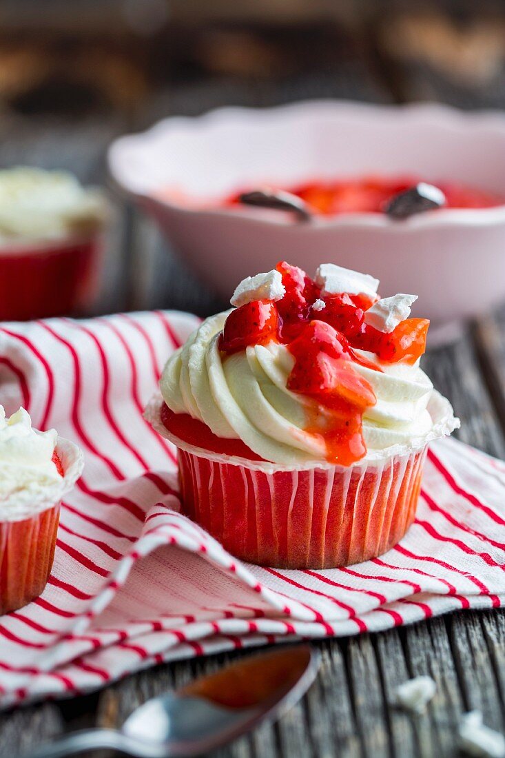 A red velvet strawberry cupcake with meringue