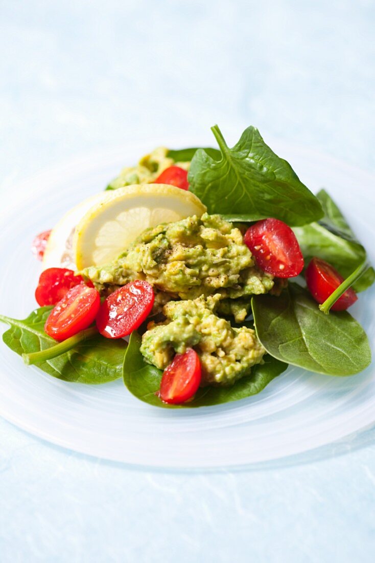 Guacamole on a mixed leaf salad with cherry tomatoes