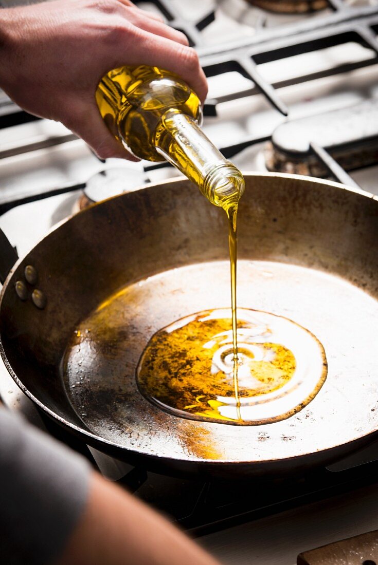 Olive oil being poured into a pan
