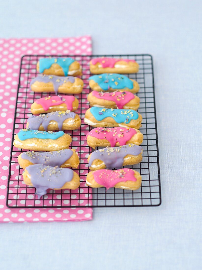 Eclairs with whipped cream, icing and dried pansy petals