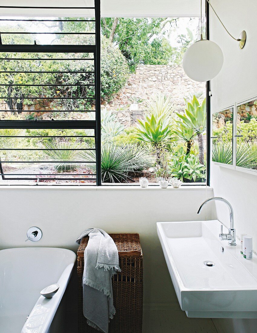 Modern sink below open window with view of garden