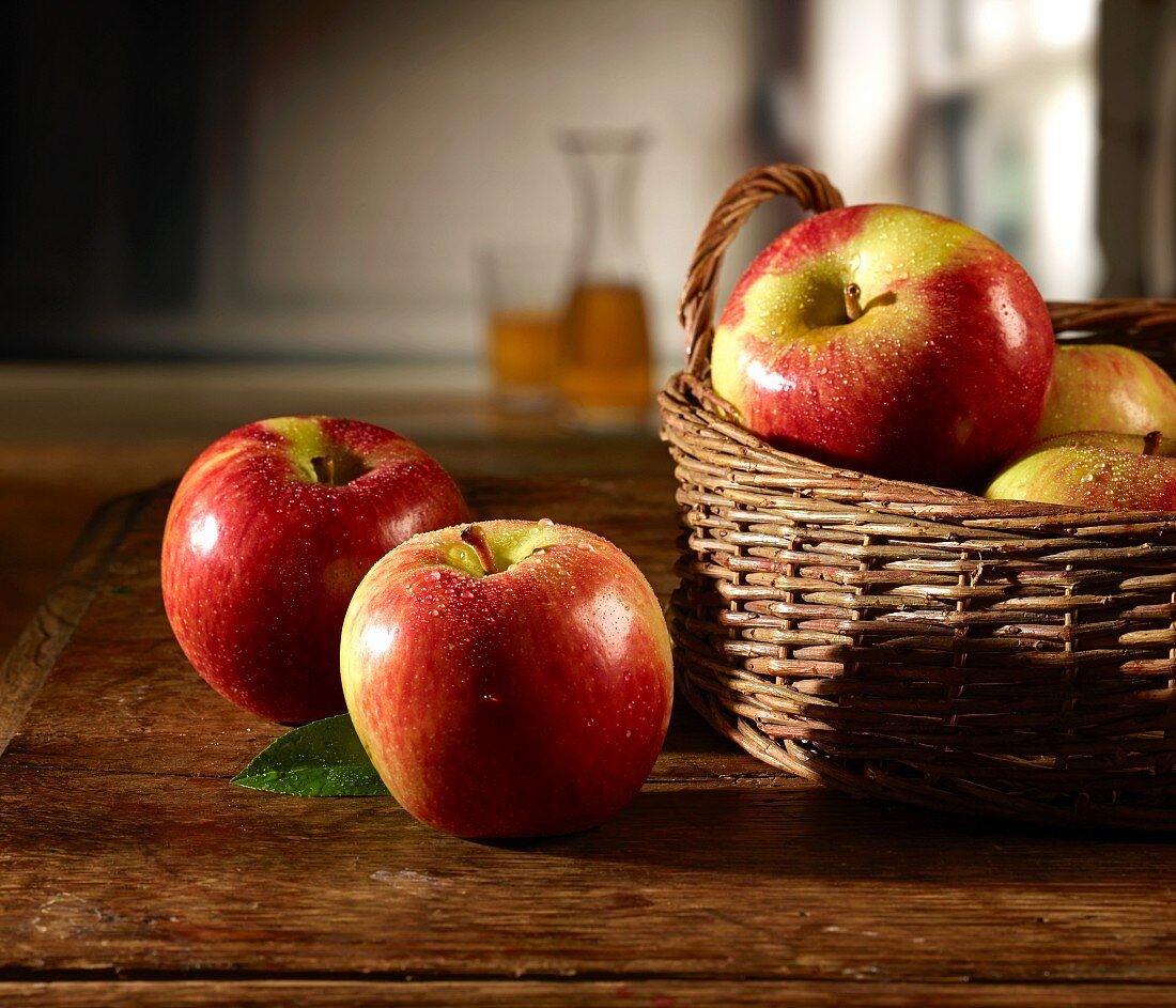 Red apples on a wooden table and in basket