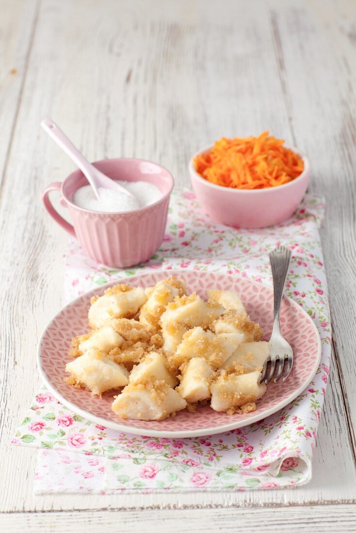 Leniwe (Polish quark dumplings) with buttered crumbs, sugar and a carrot salad
