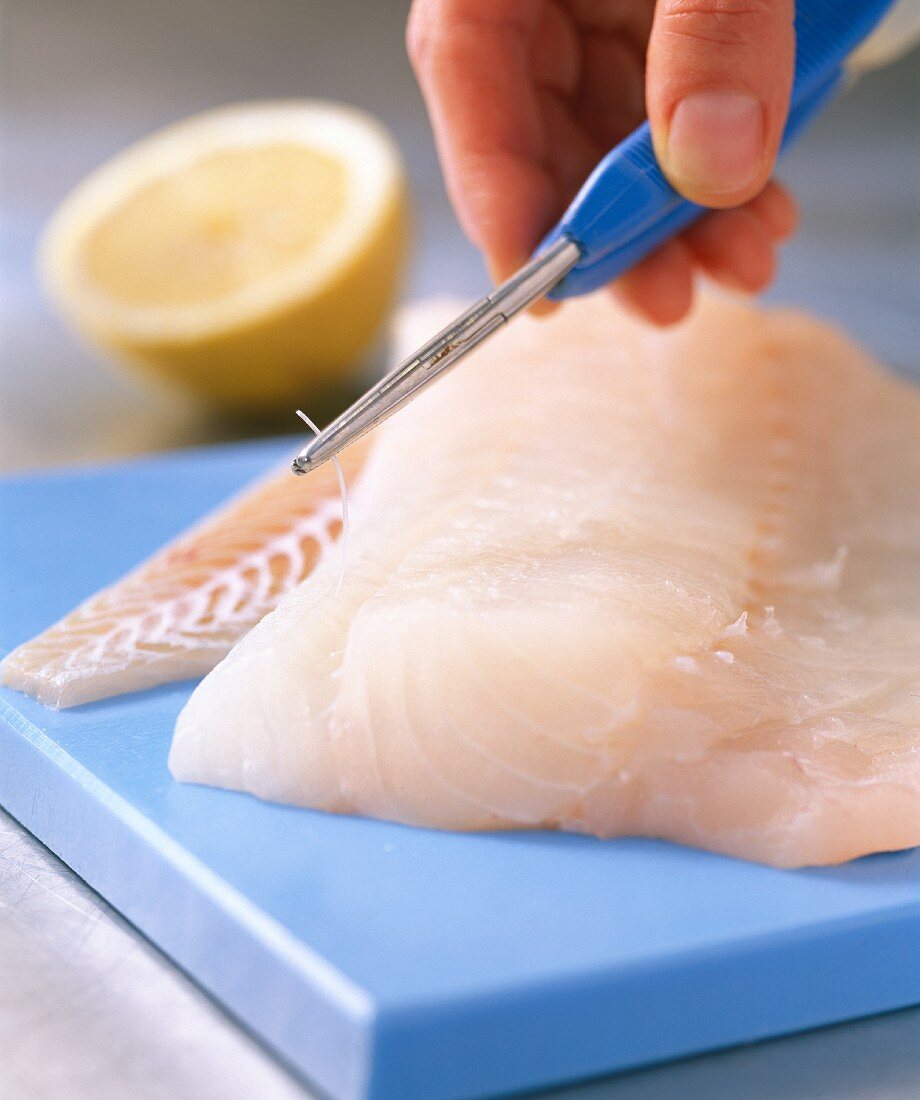 Bones being removed from a fish fillet