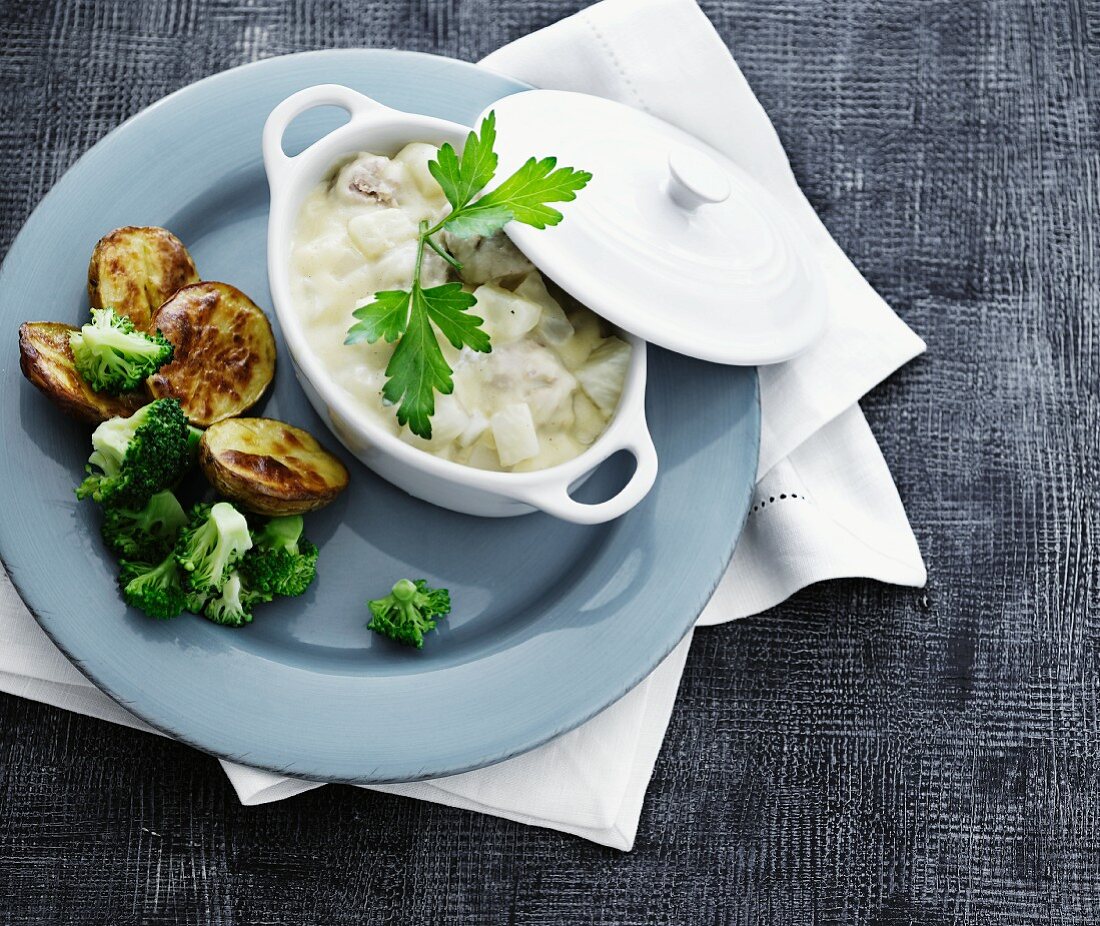 Herring with apple in a creamy sauce served with fried potatoes and broccoli