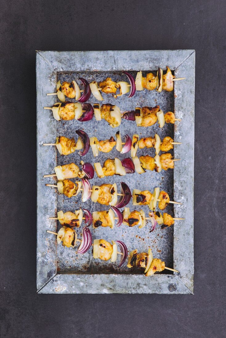 Grilled chicken skewers with pineapple and onions (seen from above)
