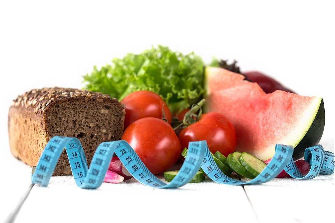 Stillleben mit Gemüse, Salat, Wassermelone, Vollkornbrot und Massband