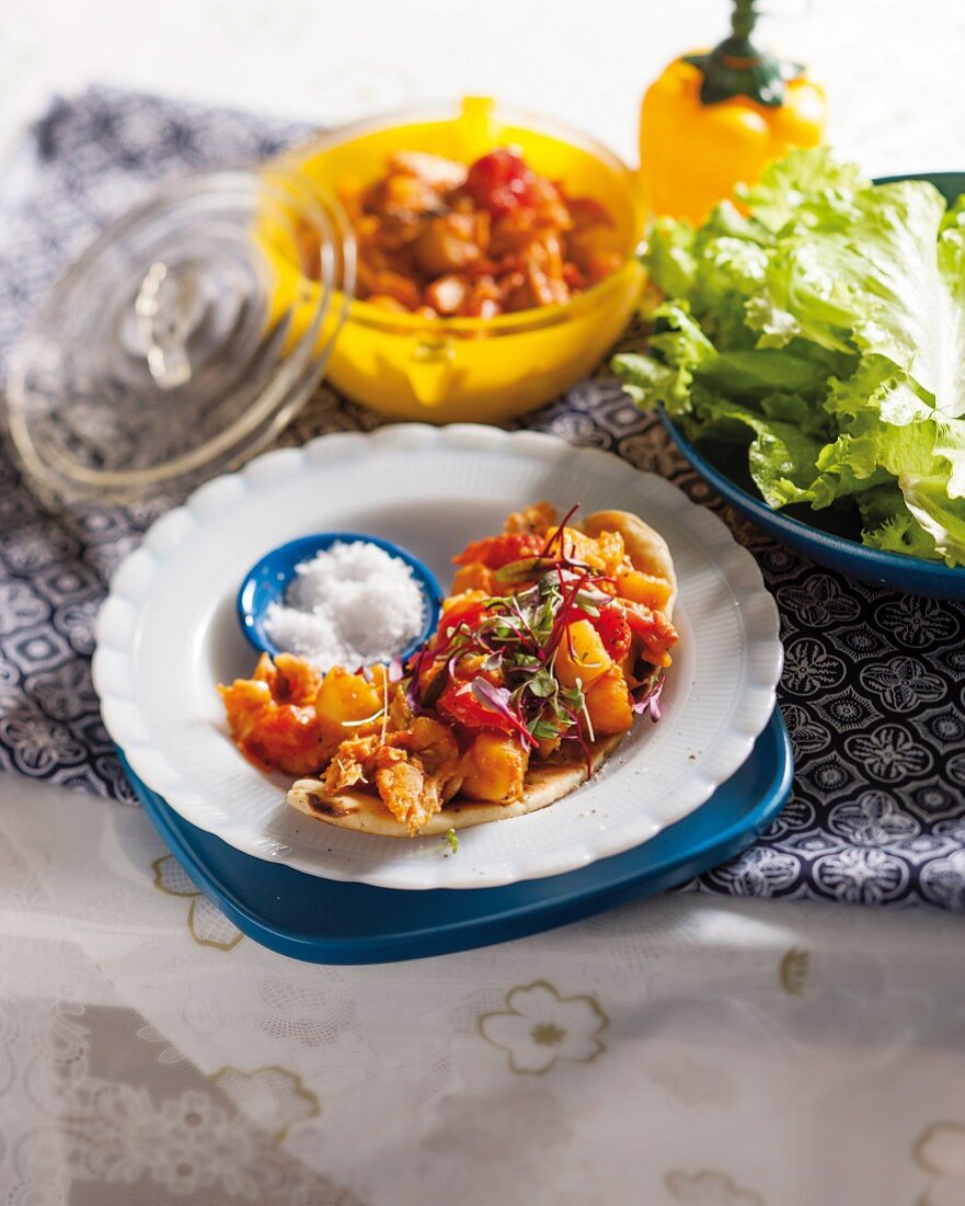 Naan bread with hake mackerel, potatoes and oven-roasted tomatoes