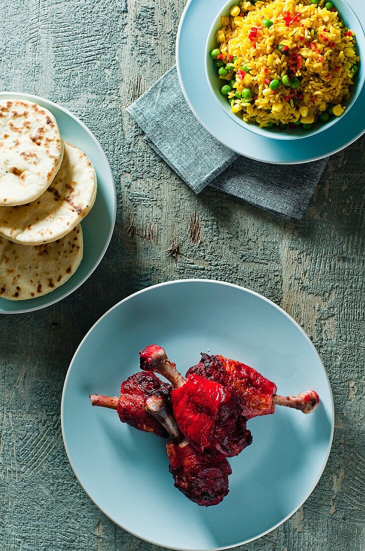 Tandoori drumsticks with fried rice and naan bread