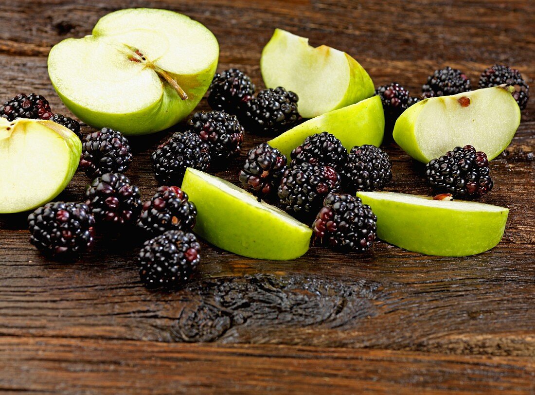 Apples and blackberries on a wooden surface