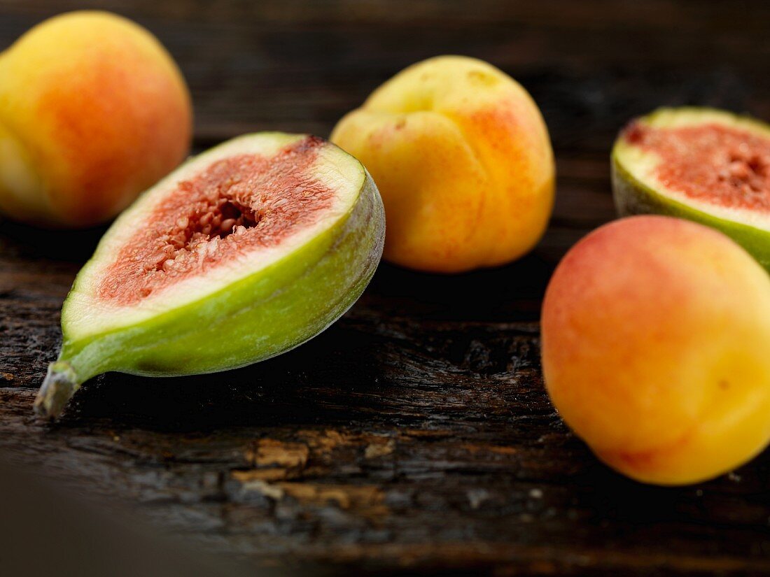 Figs and apricots on a wooden surface