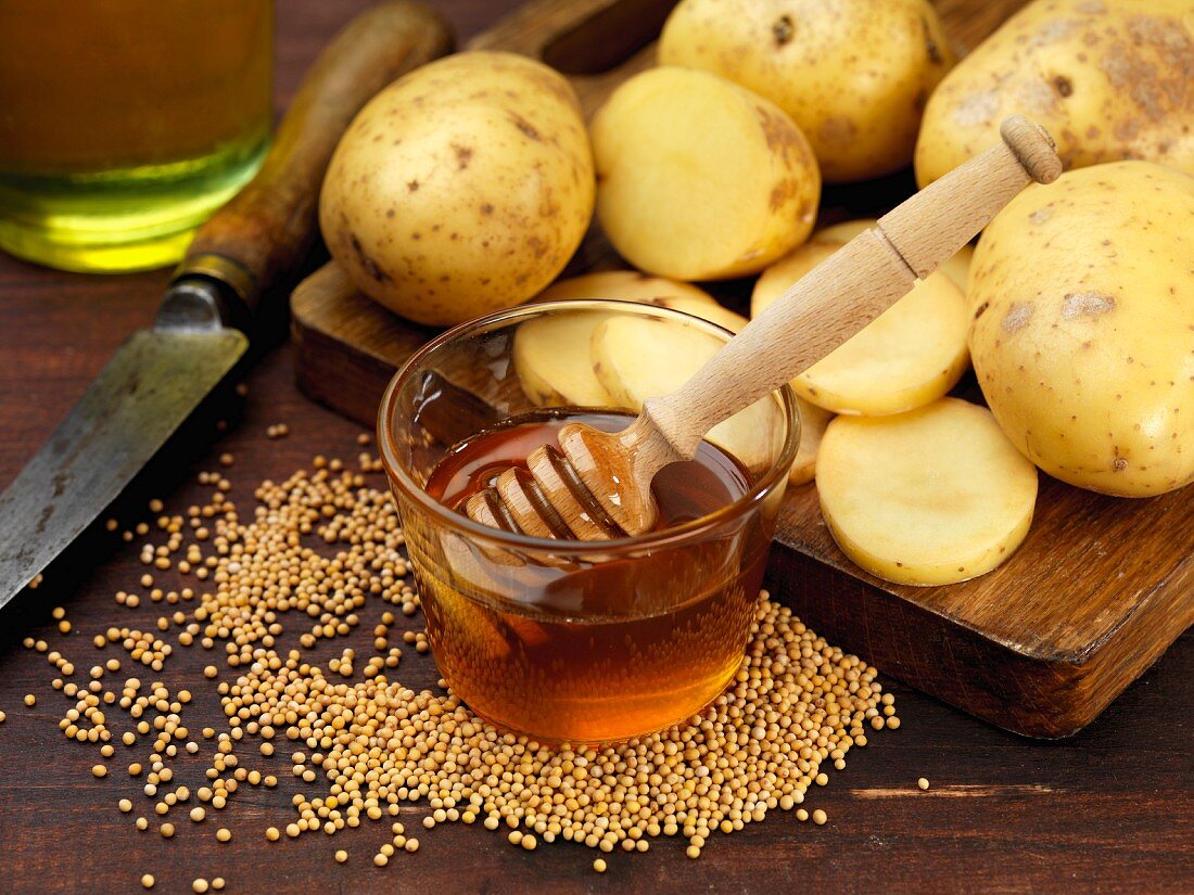Ingredients for potato crisps (honey, mustard seeds and potatoes)